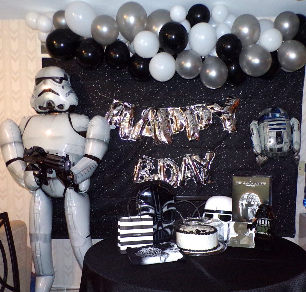 Starwars birthday set-up with life size Stormtrooper balloon, RTD2 balloon, Happy Birthday words balloon and balloon arch